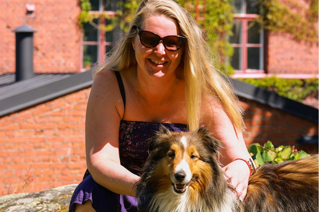 Pitkähiuksinen nainen ja pitkäkarvainen koira auringossa Lapinlahdessa.