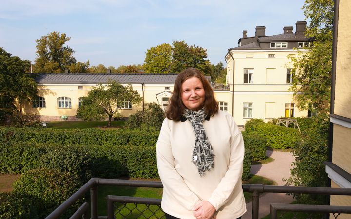 Kuvassa Katri katsoo kameraan ja hymyilee vähän.