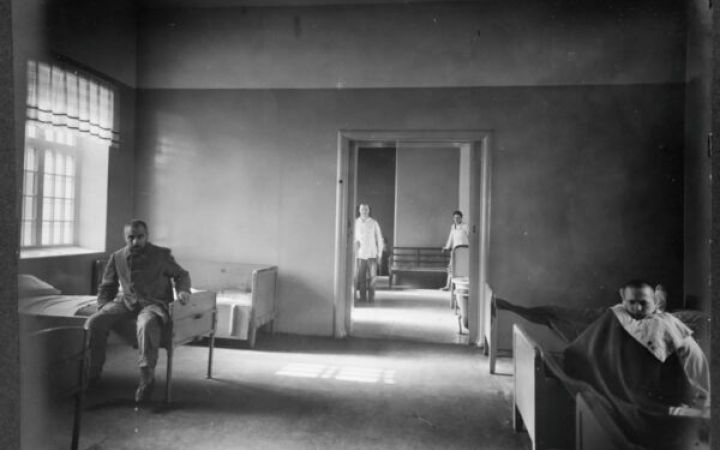 Historiallisessa, vanhassa sairaalahuoneessa muutamia miehiä.
