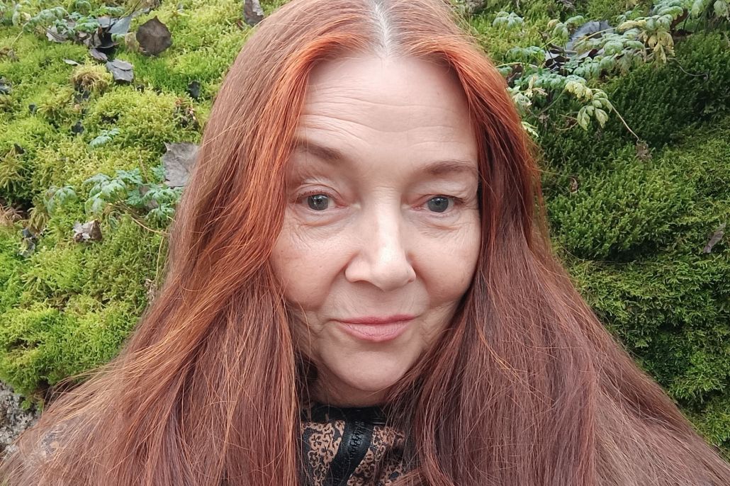 Kuvassa punatukkainen nainen.