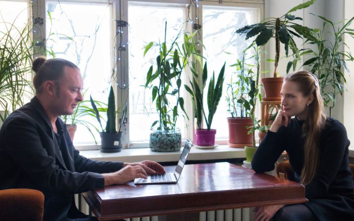 Kuvassa on mies ja nainen istumassa nojatuoleissa ikkunan edessä.