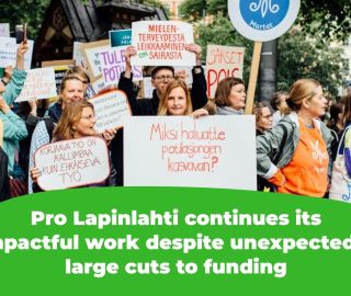 The picture shows protesters holding signs that read, among other things, "Why do you want patient queues to grow?" and "Corrective work is more expensive than preventive work" and "Cutting mental health services is sick."