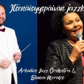 Valkopukuinen mies tahtipuikko kädessä ja tummatukkainen, mikrofoniin laulava nainen.