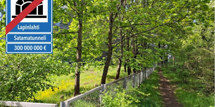 Kuva vehreästä puistopolusta. Vasemmassa yläkulmassa on liikennemerkkiä muistuttava merkki, jossa satamatunnelin yli on vedetty punainen viiva