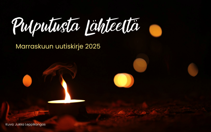 Kynttilä lepattaa hämärässä.