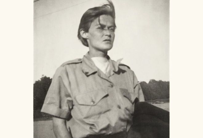 Mustavalkoinen kuva naisesta valkoisella ja keltaisella taustalla.