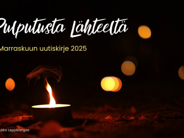 Kynttilä lepattaa hämärässä.