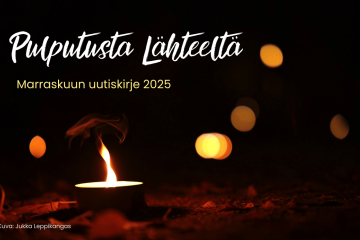 Kynttilä lepattaa hämärässä.