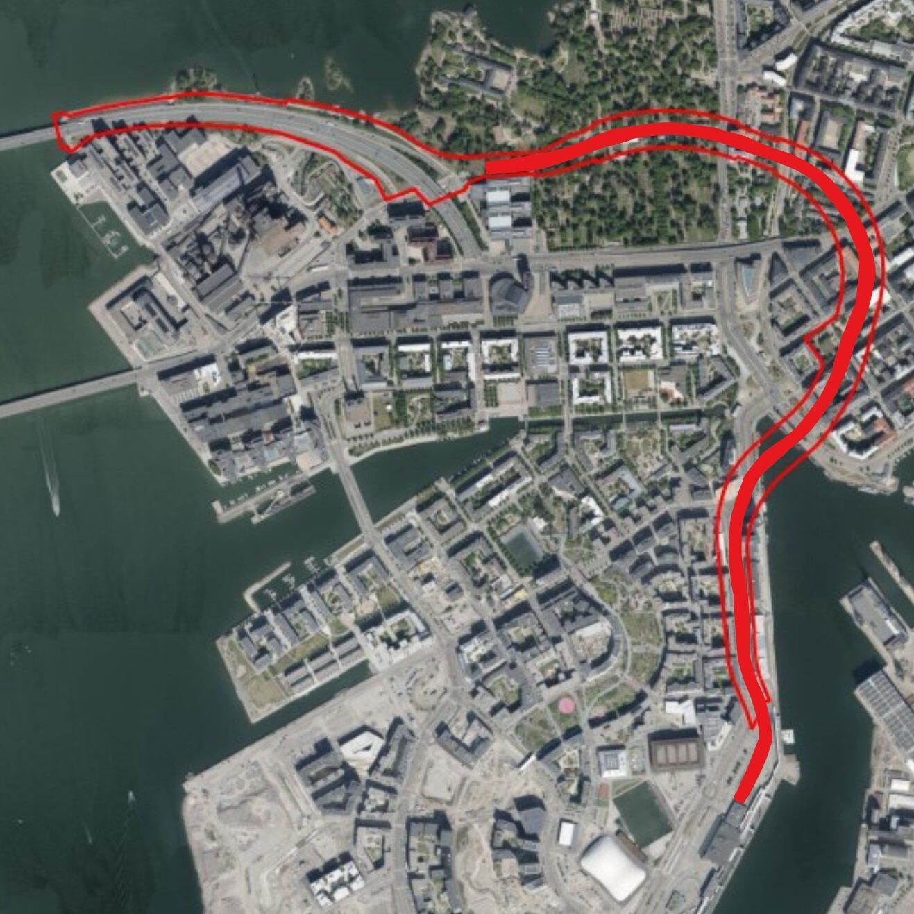 Ilmakuva Jätkäsaaresta ja Ruoholahdesta. Punaisella merkitty tunneli kulkee Länsisatamasta pohjoiseen, kiertää ison lenkin idän kautta ja kulkee länteen hautausmaiden välistä päättyen Lapinlahden puiston eteläosaan.