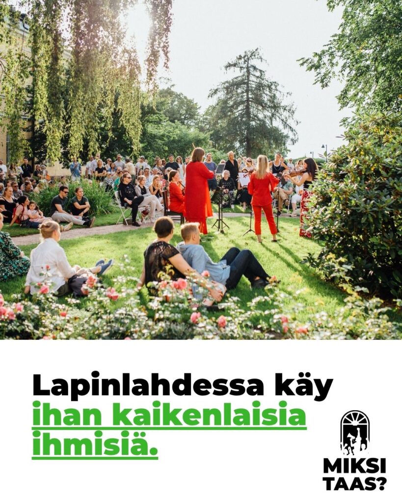 Kymmeniä ihmisiä on kerääntynyt aurinkoiselle puutarhapihalle kuuntelemaan viulutrion esitystä.