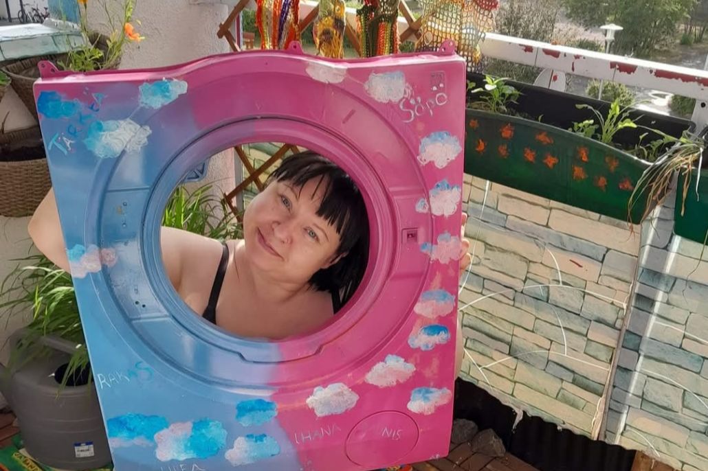 Nainen kurkistaa taideteoksen pyöreän reunan läpi.