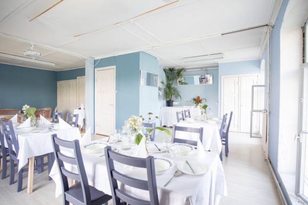 Kuvassa on katettuja pöytiä tuolineen.