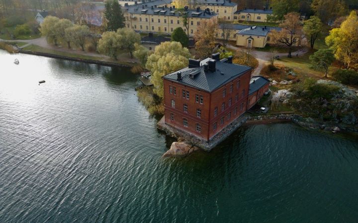 Ilmakuva veden yltä Venetsia-tiilitalosta ja Lapinlahden alueesta.