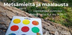 Metsämieltä ja maalausta tapahtumakuva jossa info a logot. Taustakuva on vesiväripaletti kaatuneen puunrungon päällä puistossa