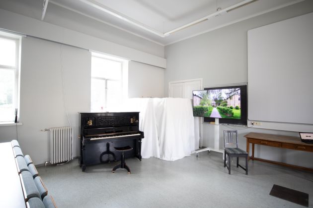 Kuvassa on auditorion piano ja televisio.