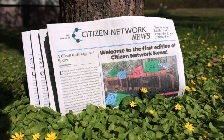 Kuvassa sanomalehti kukkien keskellä nurmikolla – Citizen Network News on uusi kansainvälinen sanomalehti