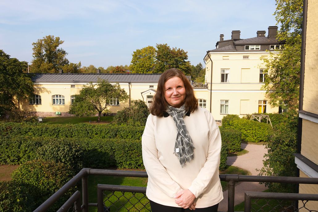 Kuvassa Katri katsoo kameraan ja hymyilee vähän.