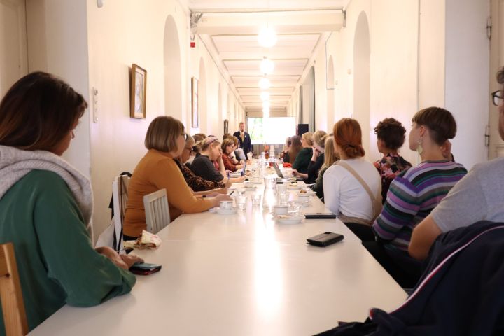 Kuvassa on ihmisiä kokouksessa Aleksis Kiven juhlatilassa.