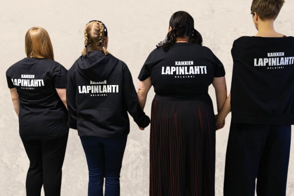 Neljä naista mustissa Kaikkien Lapinlahti -t-paidoissa selkäpuolelta kuvattuna