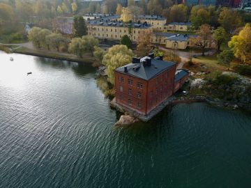 Ilmakuva veden yltä Venetsia-tiilitalosta ja Lapinlahden alueesta.