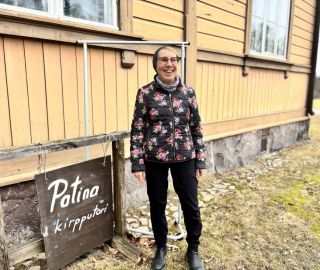 Seisova nainen kukikkaassa takissa