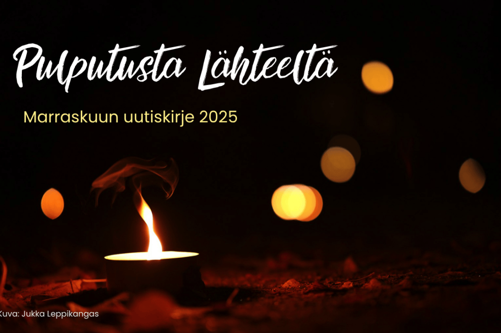 Kynttilä lepattaa hämärässä.