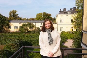 Kuvassa Katri katsoo kameraan ja hymyilee vähän.