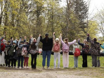 Kuvassa Jätkäsaaren kolmosluokkalaisia suojelemassa Lapinlahden puistoa käsi kädessä takaapäin kuvattuna