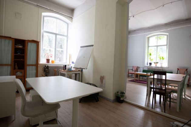 Kuvassa on Avoin tila nurkasta kuvattuna, etualalla vasemmalla on pöytä.