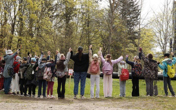 Kuvassa Jätkäsaaren kolmosluokkalaisia suojelemassa Lapinlahden puistoa käsi kädessä takaapäin kuvattuna