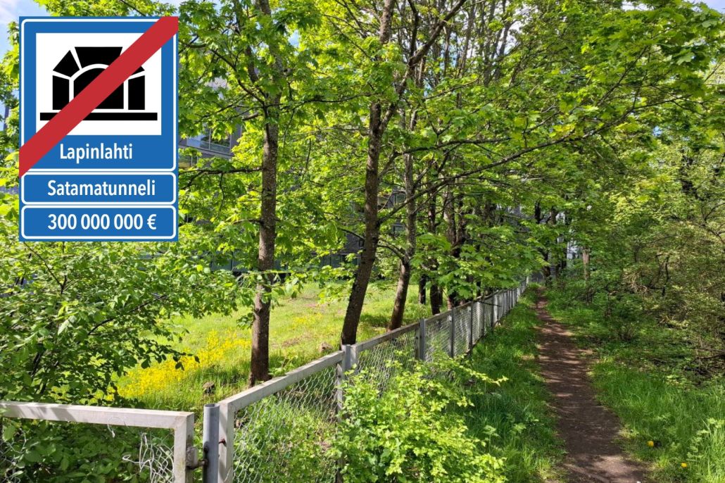 Kuva vehreästä puistopolusta. Vasemmassa yläkulmassa on liikennemerkkiä muistuttava merkki, jossa satamatunnelin yli on vedetty punainen viiva