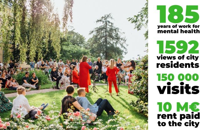 A group of people have gathered in the sunny garden to listen to a concert by a violin trio.