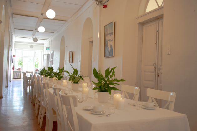 Kuvassa on katettuja pöytiä Aleksis Kiven juhlatilassa.