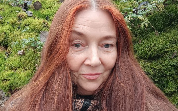 Kuvassa punatukkainen nainen.