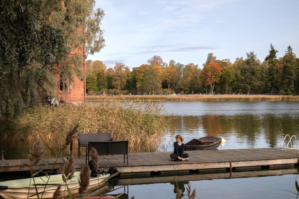 Kuvassa laituri ja Venetsia-rakennus, laiturilla nuori nainen.
